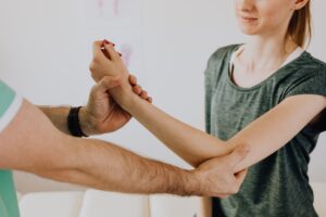 Doctor examining a patient's wrist and forearm during an arm pain evaluation