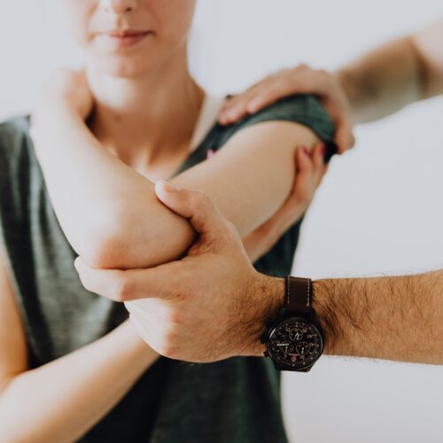Doctor examining a female patient's elbow and arm for pain