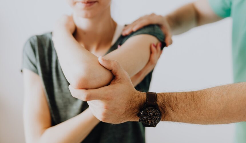 Doctor examining a female patient's elbow and arm for pain